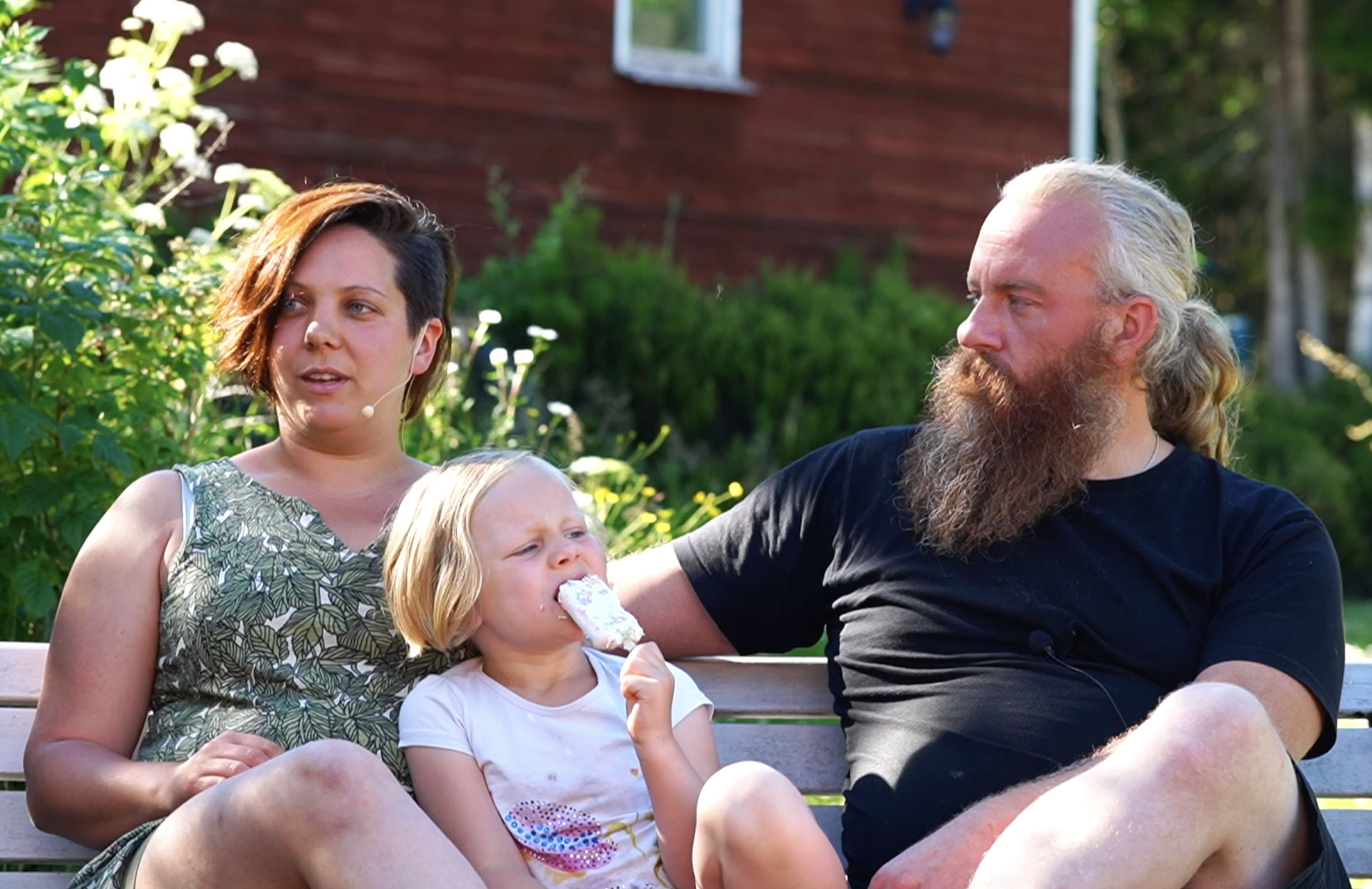 Familj med dotter sittande på en bänk