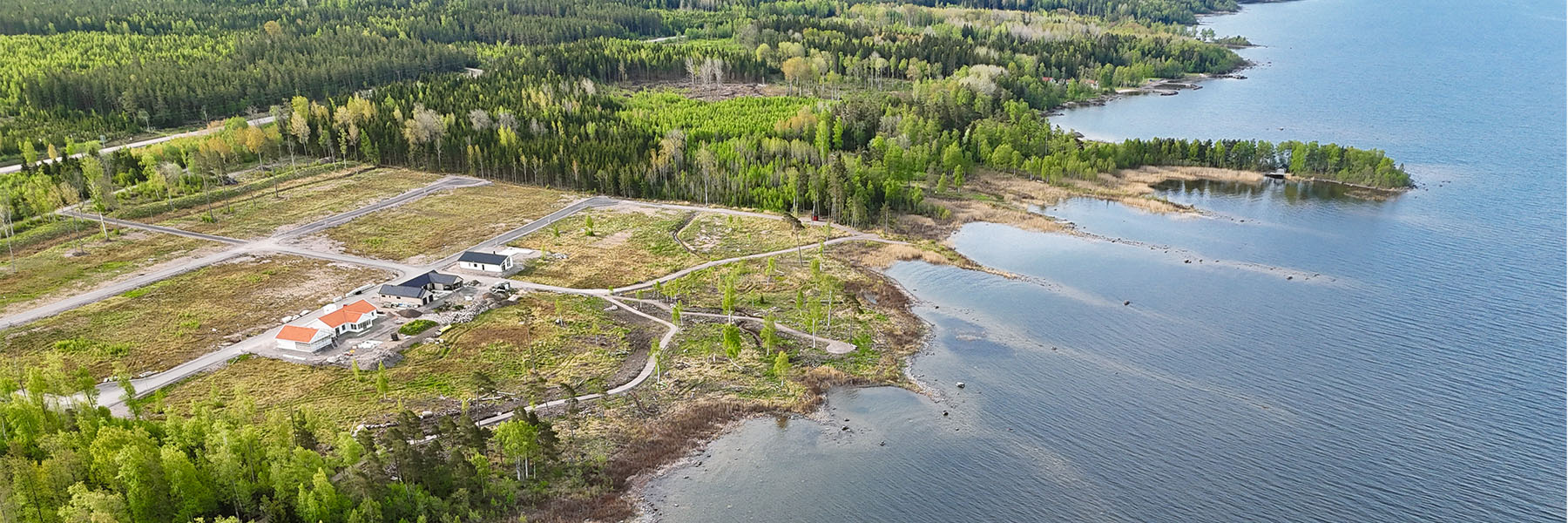 Sjögläntan Drönarbild över ett nytt bostadsområde vid vattnet